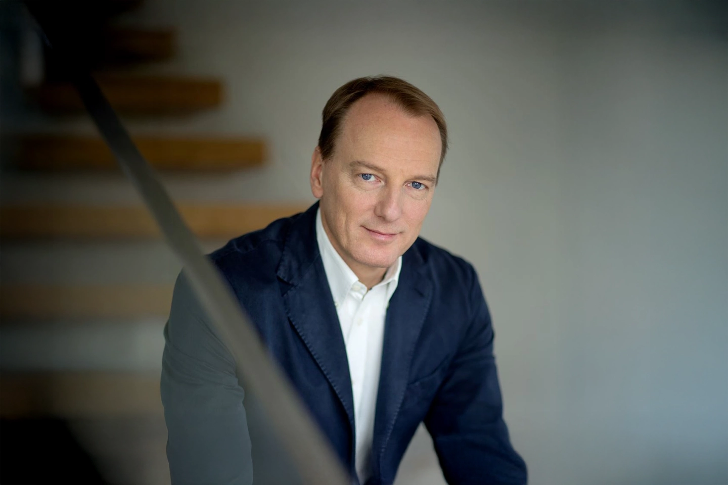 Autor Marc Elsberg lächelt in die Kamera. Er trägt einen dunkelblauen Anzug.