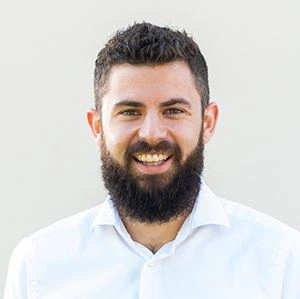 Anton Schilling trägt dunkles Haar, einen vollen Bart und ein weißes Hemd.